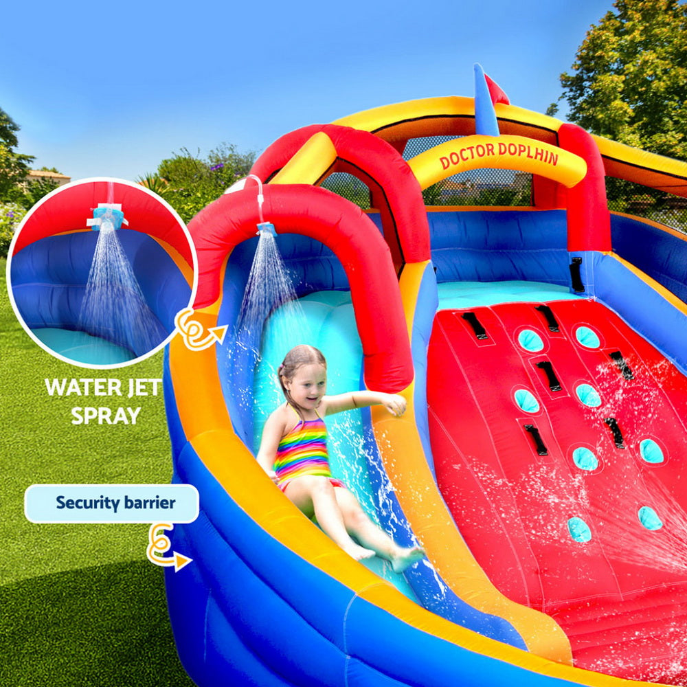 Inflatable water slide with water jet spray feature and child playing on grass.