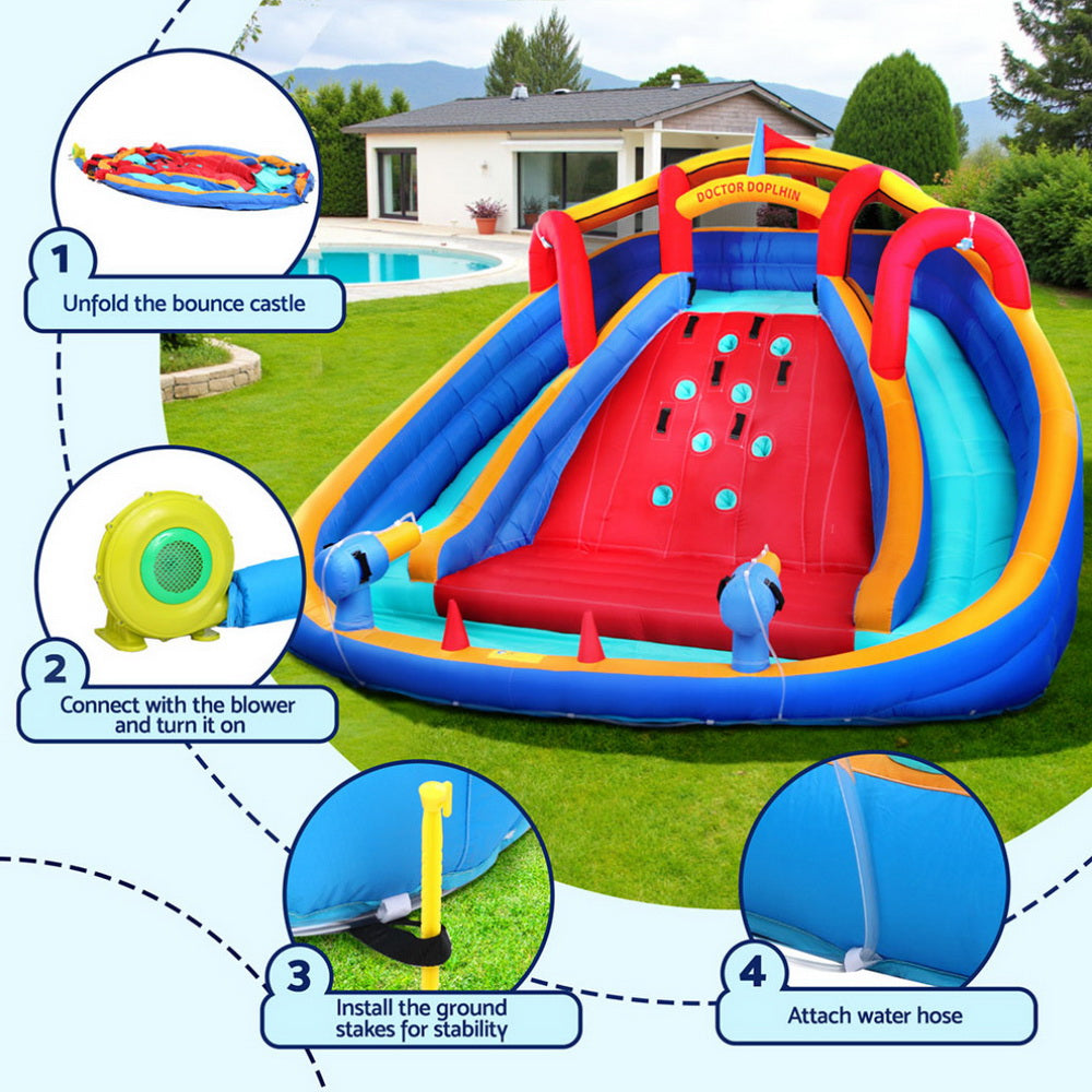 Inflatable bounce castle with slides and water features on a grassy lawn.