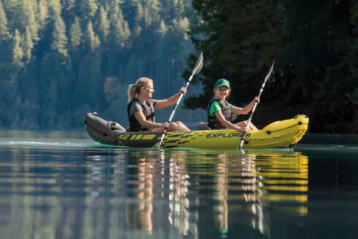 Two people paddling a yellow inflatable kayak on a calm lake with trees in the background