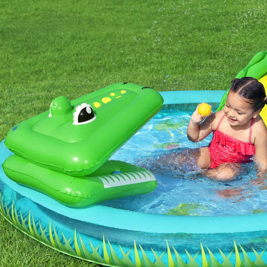 Child playing with an inflatable crocodile pool toy in a backyard pool.